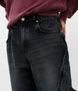 Pantalón de jean corte super baggy, de color azul claro con efecto lavado. Presenta un diseño de pierna ancha con costuras laterales destacadas con detalles deshilachados y bolsillos funcionales.