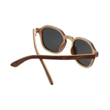Lentes de sol con marco de madera color marrón y lentes grises.