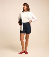 Short de sastrería azul marino con cintura alta y fila de botones frontales revestidos.
