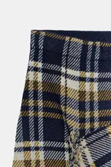 Falda midi de tiro medio confeccionada en tejido de punto con estampado de cuadros. Presenta un diseño envolvente con bajo asimétrico y detalles de flecos en los bordes.