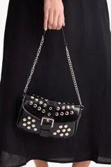 Bandolera de poliuretano símil cuero color negro, decorada con tachas metálicas plateadas. Cuenta con solapa frontal, cierre con hebilla decorativa, y correa de hombro combinada con cadena de eslabones plateados.