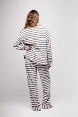 Pijama de tela tipo velvet a rayas horizontales grises y blancas, con vivos en color rojo. Incluye camisa de manga larga con botones frontales y bolsillo en el pecho, y pantalón recto con elástico en la cintura.