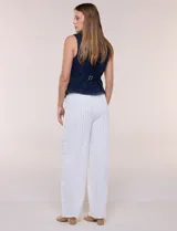 Chaleco de denim azul con silueta entallada, escote redondo cerrado, hilera de botones metálicos frontales y costuras anatómicas.