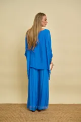 Blusa verde manzana de corte holgado y asimétrico, con mangas murciélago midi y escote redondo.