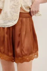 Short de satén de viscosa color verde militar, con apliques de encaje a tono en el ruedo y cierre invisible lateral.