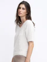 Sweater de punto color beige, de manga corta y corte holgado.