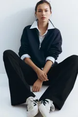 Pantalón negro de punto de algodón, corte ancho y recto, con cintura alta tipo fajín plegable.