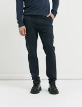 Pantalon de corte clasico confeccionado en algodon sarga con elastano, color marron. Presenta bolsillos delanteros inclinados y bolsillos traseros de ribete con boton.