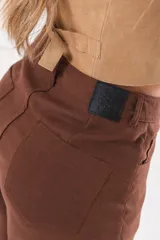 Bermuda de silueta amplia y tiro medio, color marrón chocolate, con bolsillos delanteros y traseros, cierre frontal con cremallera y botón.