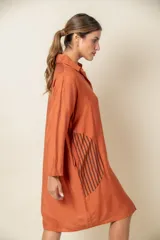 Túnica marrón de viscosa texturizada con cierre de botones, bolsillos laterales y detalle de rayas verticales en los bolsillos.