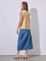 Blusa estampada color amarillo con flores blancas, de corte recto y mangas cortas con volados. Presenta frunces en la parte delantera y abertura con botón en la espalda. Marca Premise.
