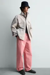 Pantalón relaxed fit color rosado, confeccionado en tejido de algodón con efecto lavado. Presenta pliegues frontales, bolsillos delanteros y bolsillos traseros de vivo. Cierre frontal con cremallera y botón.