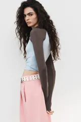 Pantalón ancho de tiro medio, color rosa pálido, con pinzas delanteras y bolsillos laterales y traseros.