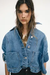 Jeans de tiro alto con diseño wide leg y corte cropped. Presenta cinco bolsillos, cierre frontal con cremallera y botón metálico.