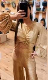 Pantalón de tiro alto confeccionado en tejido de lamé dorado con acabado brillante y corte ligeramente evasé.