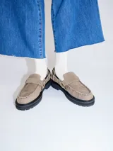 Mocasines de cuero negro con plataforma, diseño tipo náutico con costuras reforzadas en la puntera, detalle de tira sobre el empeine con apliques metálicos y argollas laterales.