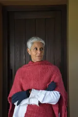 Ruana artesanal tejida en telar con pura lana Merino, en color rojo. Presenta diseño amplio y envolvente con flecos en los extremos.