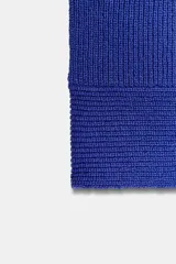 Top tejido de punto color azul eléctrico, con escote en V y sisas anchas.