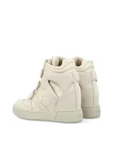 Zapatilla de caña alta, color blanco hueso, con cierre de tres tiras de velcro. Presenta recortes en gamuza y paneles acolchados en el lateral, con suela de goma gruesa.