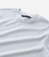 Remera de manga corta, cuello redondo y calce ajustado (slim fit), color gris claro, con textura acanalada vertical.