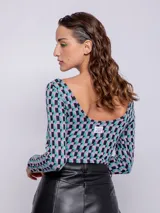Top de tejido de punto con estampado geométrico en blanco y negro, de manga larga y cuello redondo.