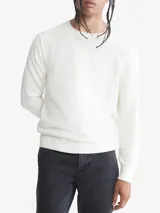 Sweater de punto liso color blanco, con cuello redondo y puños y dobladillo en punto canalé.