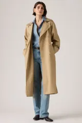 Trench coat largo de corte clásico en color beige, con diseño de doble botonadura, solapas amplias y cuello con detalle de textura. Presenta un estilo atemporal y estructurado.