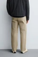 Pantalón de corte recto confeccionado en tejido de sarga con estructura diagonal. Presenta cintura elástica, bolsillos delanteros, bolsillos traseros de vivo y cierre frontal con cremallera y botón.