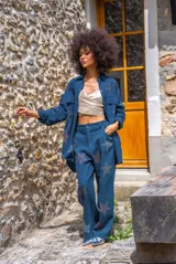 Pantalón azul con estampado de estrellas brillantes, de corte recto y fluido, cintura alta con trabillas para cinturón, cierre con botón y cremallera, bolsillos laterales.