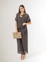 Pantalón de seda italiana con forro de viscosa elastizada, de corte holgado y diseño fluido, con detalles de paillettes en los costados y cintura elastizada.