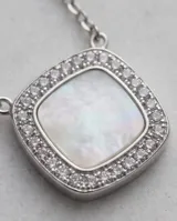 Collar de acero con dije cuadrado de nácar rodeado de circonias y cadena de eslabones finos.