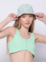 Top blanco de tela texturada, sin mangas y con cuello redondo. Cuenta con cuatro botones y terminación en curva en la parte delantera.