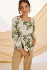 Blusa de manga larga con estampado floral en tonos verde y blanco.