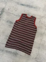 Vestido corto de tejido calado, de color marrón con rayas horizontales blancas y detalles en rojo óxido en el cuello y las sisas.