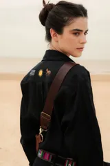 Camisa azul marino de lino con botones, mangas largas y bordados de caballito, sol y la bandera de Uruguay.