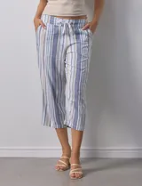 Pantalón capri de lino estampado con rayas verticales en tonos rosa, gris y amarillo. Tiene pretina ancha elastizada, bolsillos inclinados en la parte delantera y cordón ajustable en la cintura.