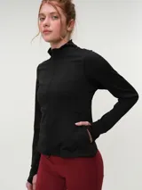 Campera deportiva marrón con cuello alto y cierre frontal completo. Presenta mangas largas con orificio para el pulgar y corte ajustado.
