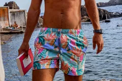 Short de baño La Juanita con estampado tropical multicolor de hojas y flores. Posee elástico en la cintura con cordón ajustable, dos bolsillos laterales y uno trasero, con interior de red y tela de secado rápido.