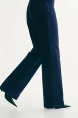 Jean de denim azul oscuro con tiro alto, piernas rectas y pliegues marcados al frente y en la espalda. Cuenta con cierre de botón y bolsillos delanteros insertados.
