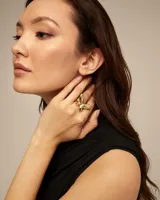 Anillo de metal dorado con forma de mariposa de gran tamaño.