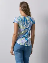 Remera color beige con estampado de hojas blancas, cuello redondo y mangas cortas.