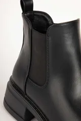 Botas Chelsea negras de cuero sintético, con elástico en los laterales, punta redonda y suela track de 6 cm de alto.