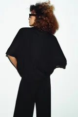 Remera oversize gris melange de tejido fluido, con cuello redondo y mangas cortas amplias.