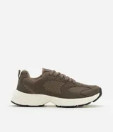 Championes de estilo deportivo urbano, confeccionados en material sintético con paneles de malla y detalles texturizados. Presentan un diseño robusto con suela de goma gruesa en color blanco y base de rodadura negra, cierre mediante cordones y forro interior acolchado.