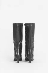 Bota de caña media confeccionada en cuero negro, con diseño de punta fina y taco bajo tipo kitten heel.