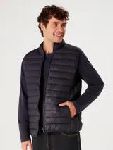 Chaleco puffer color verde oliva con cierre frontal y bolsillos laterales.