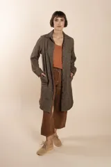 Camisa larga color beige con botones dorados y bolsillo plaque en la delantera. Confeccionada en lana fina sin teñir, diseñada exclusivamente por Don Baez. Hecha 100% en Uruguay.