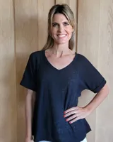 Remera negra de algodón tramado, con cuello en V, mangas cortas con vuelta y diseño holgado.