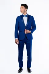 Ambo de fiesta Florenzi modelo Selvino, color azul vibrante con textura sutil. El saco presenta solapas en punta de raso, cierre de un botón forrado y abertura trasera. El pantalón es de corte slim fit.