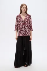 Blusa de viscosa bordó con estampado abstracto, escote en V con cuello tipo solapa y mangas 3/4, de corte holgado.